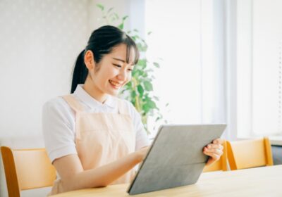 保育士がタブレットを持っている写真